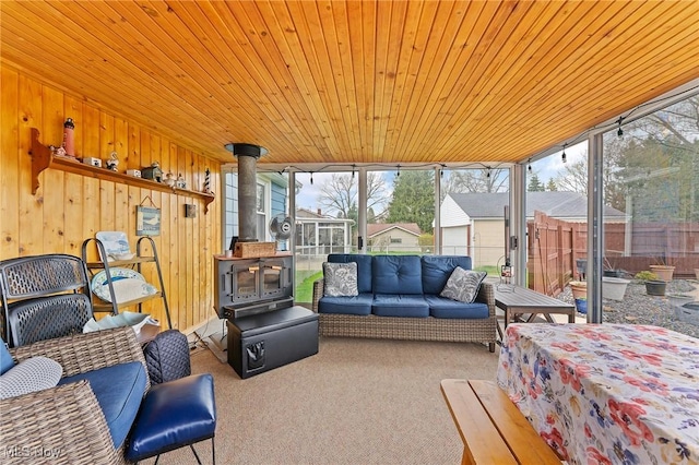 sunroom / solarium with a wood stove and an outdoor living space