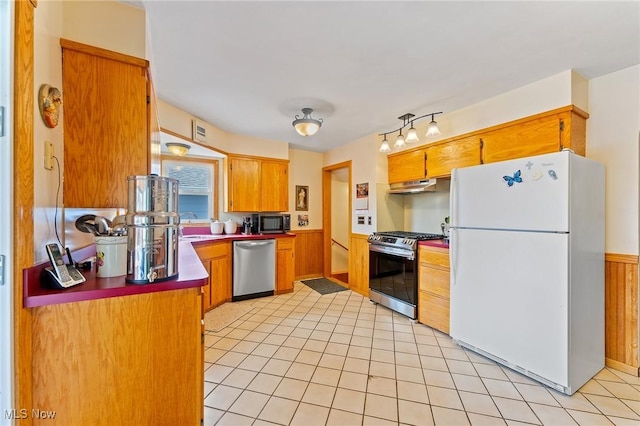 kitchen with stainless steel appliances, under cabinet range hood, and brown cabinets