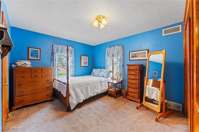 carpeted bedroom with a textured ceiling and visible vents