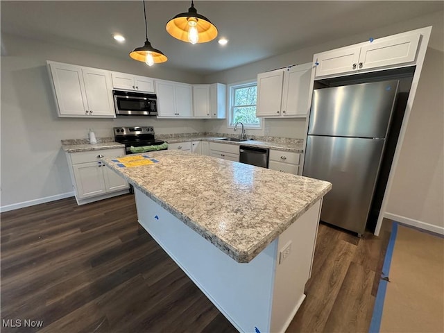 738 Mineral Springs Ave, Youngstown, OH 44511 - kitchen with stainless steel appliances, baseboards, dark wood-type flooring, white cabinetry, and a center island