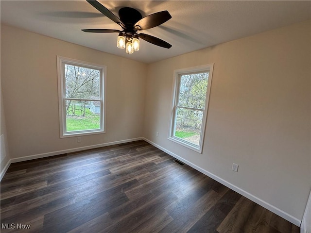 738 Mineral Springs Ave, Youngstown, OH 44511 - empty room with plenty of natural light, dark wood-type flooring, and baseboards