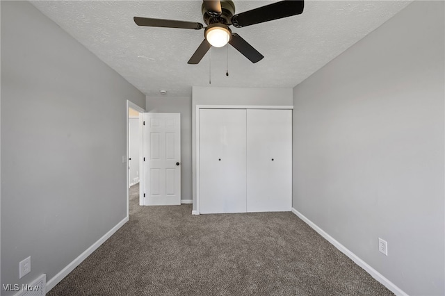 unfurnished bedroom featuring a ceiling fan, a textured ceiling, a closet, carpet, and baseboards