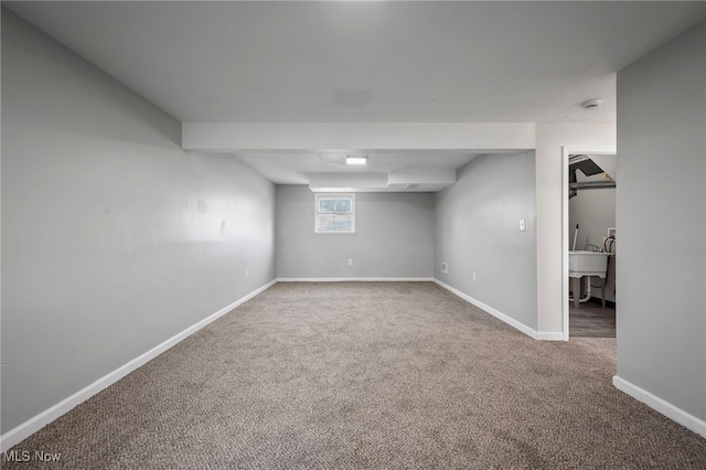 below grade area featuring baseboards and carpet