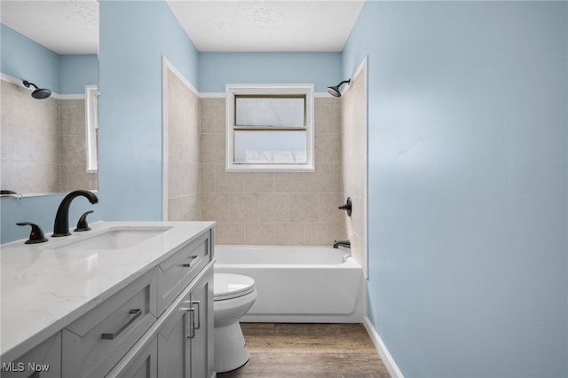 bathroom with toilet, vanity, wood finished floors, and bathing tub / shower combination