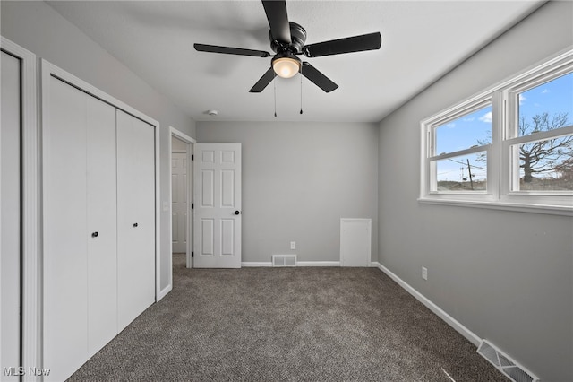 unfurnished bedroom with baseboards, visible vents, carpet floors, and a closet