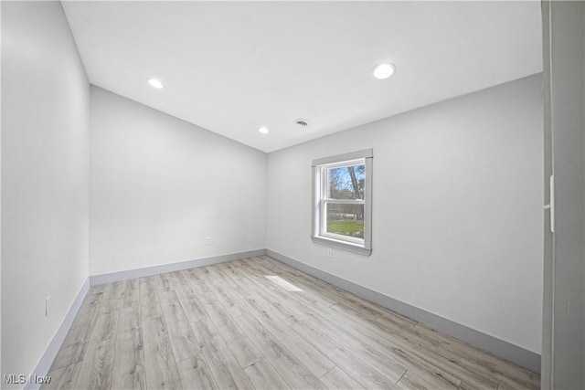unfurnished room with baseboards, wood finished floors, visible vents, and recessed lighting