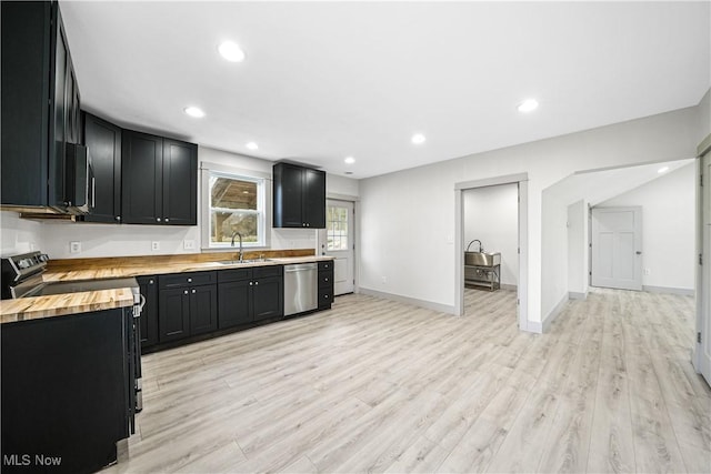 kitchen featuring light wood finished floors, stainless steel dishwasher, electric range, dark cabinets, and wood counters