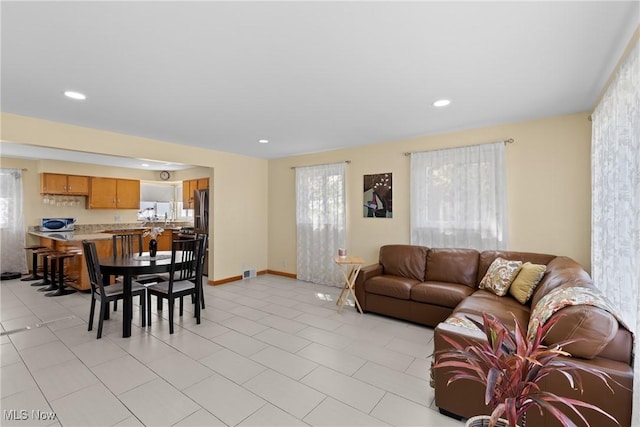 living room featuring baseboards, visible vents, and recessed lighting