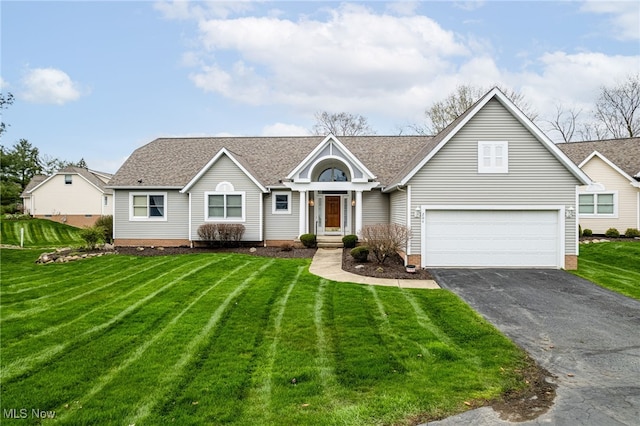 view of front of home with a garage, driveway, a front yard, and roof with shingles