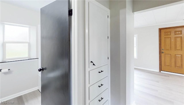 hallway featuring light wood-type flooring and baseboards