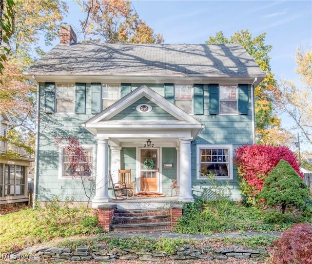 view of front of house with a chimney and a porch