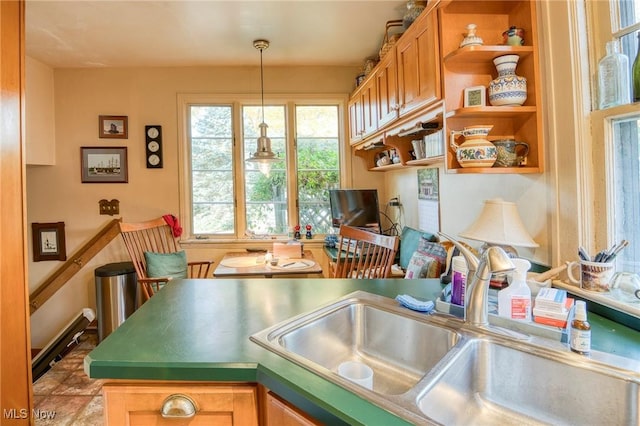 kitchen with open shelves, a sink, and hanging light fixtures