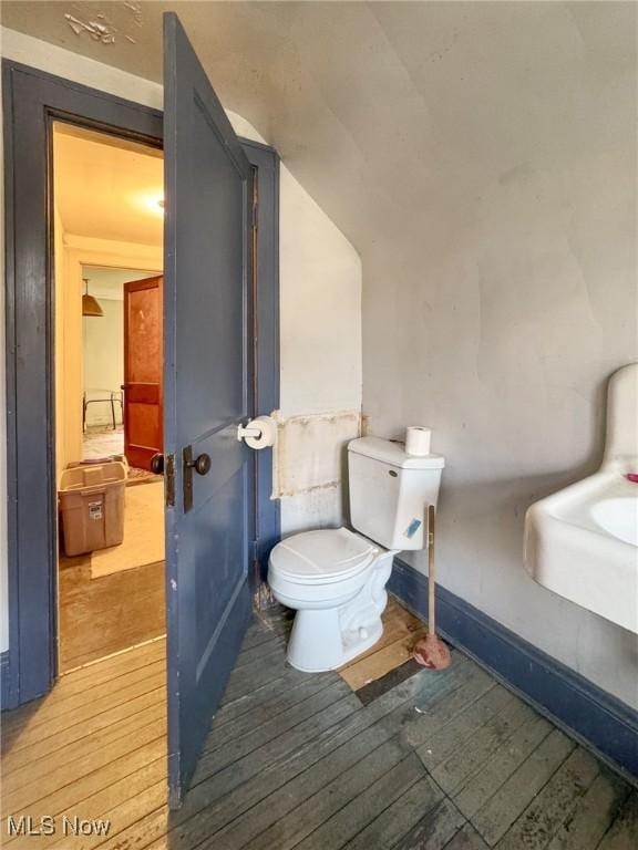bathroom featuring toilet, wood finished floors, and baseboards