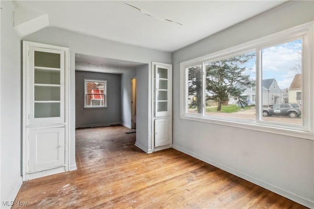 empty room with light wood-style flooring and baseboards