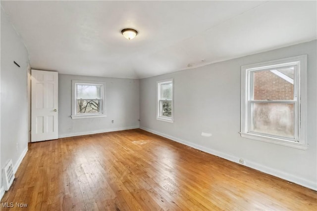 empty room with baseboards, visible vents, and light wood-style flooring