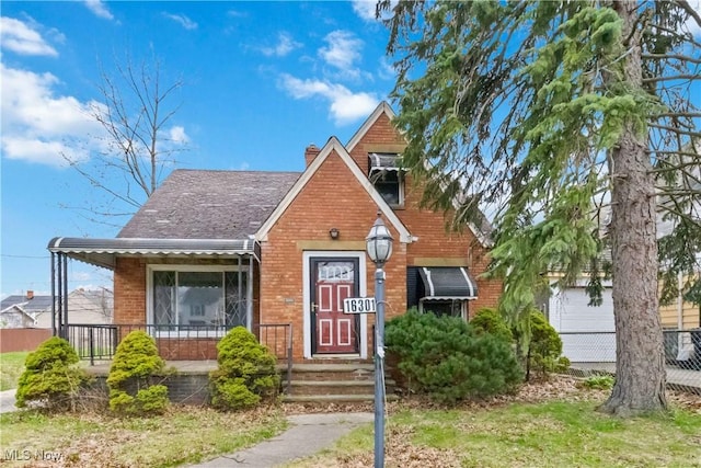 bungalow-style house with brick siding, a porch, and a chimney