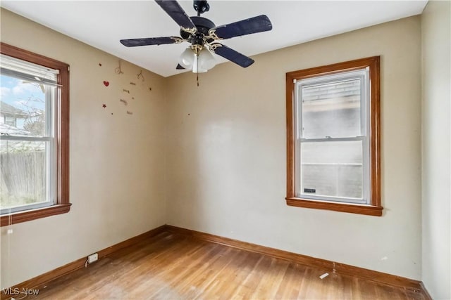 spare room with light wood-type flooring, baseboards, and ceiling fan