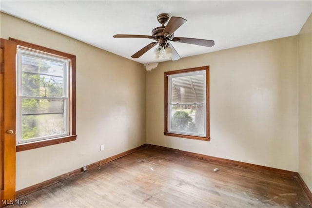 spare room with baseboards, a ceiling fan, and wood finished floors