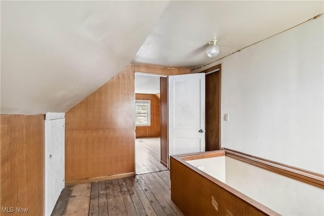 additional living space with vaulted ceiling and wood-type flooring