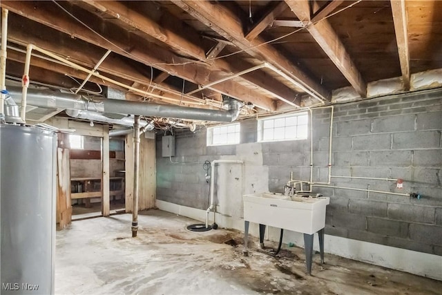 basement with water heater, a sink, and electric panel