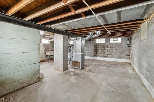 below grade area featuring heating unit and a sink