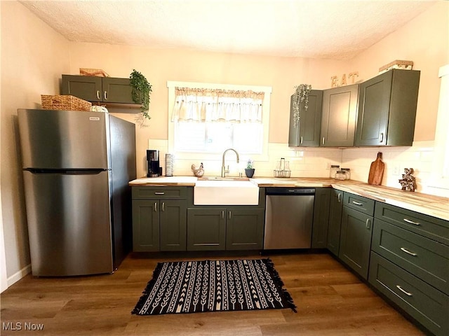222 Smith St, Niles, OH 44446 - kitchen featuring a sink, light countertops, dark wood finished floors, backsplash, and appliances with stainless steel finishes