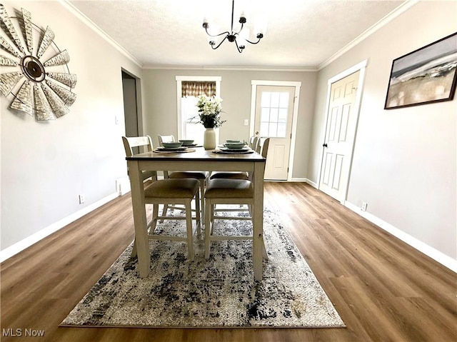 222 Smith St, Niles, OH 44446 - dining area with crown molding, baseboards, a notable chandelier, and wood finished floors