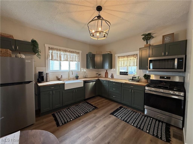 222 Smith St, Niles, OH 44446 - kitchen featuring a sink, backsplash, a chandelier, light countertops, and appliances with stainless steel finishes