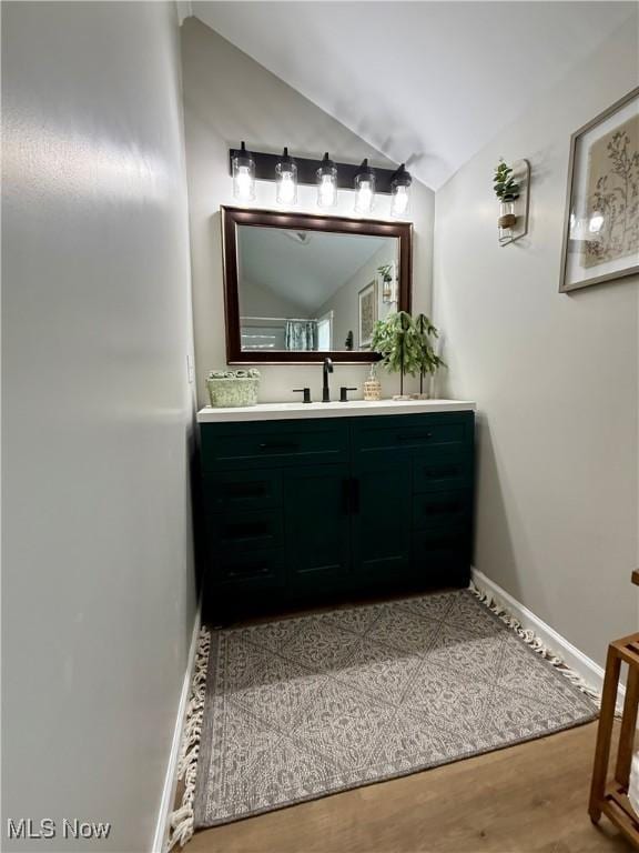 222 Smith St, Niles, OH 44446 - bathroom featuring lofted ceiling, vanity, wood finished floors, and baseboards