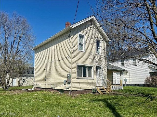 222 Smith St, Niles, OH 44446 - view of side of home with a chimney, a yard, and entry steps
