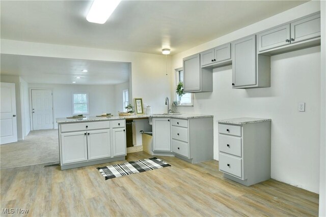5099 Norquest Blvd, Youngstown, OH 44515 - kitchen featuring a peninsula, light wood-style flooring, gray cabinetry, and a sink