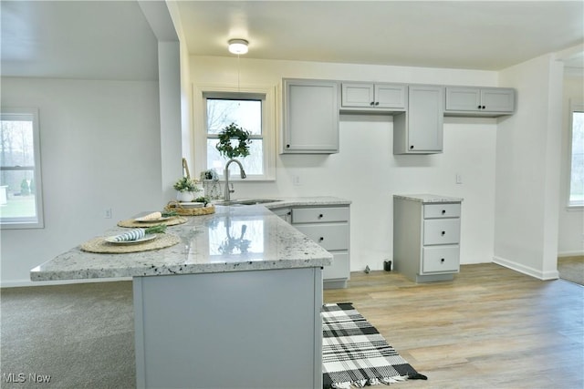 5099 Norquest Blvd, Youngstown, OH 44515 - kitchen featuring gray cabinets, a healthy amount of sunlight, light stone countertops, and a sink