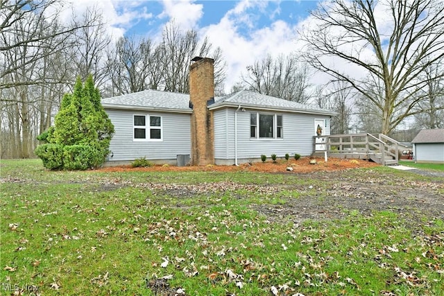5099 Norquest Blvd, Youngstown, OH 44515 - back of house with a lawn, a shingled roof, a chimney, and central AC unit