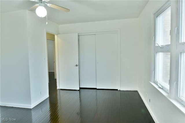 5099 Norquest Blvd, Youngstown, OH 44515 - unfurnished bedroom with baseboards, dark wood-style flooring, multiple windows, and a closet
