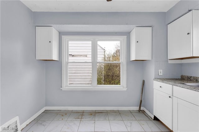 unfurnished dining area with visible vents, baseboards, and marble finish floor