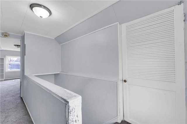 hall with lofted ceiling and carpet