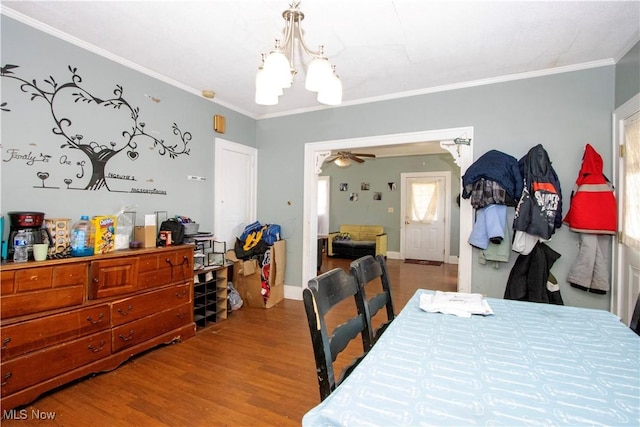 dining space featuring a ceiling fan, baseboards, ornamental molding, and wood finished floors