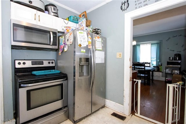kitchen with crown molding, white cabinetry, baseboards, appliances with stainless steel finishes, and visible vents