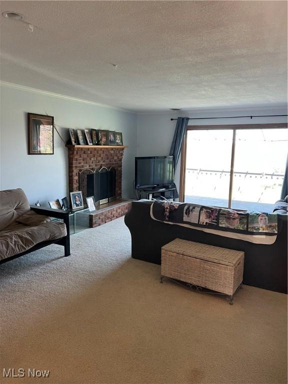carpeted living room featuring a fireplace, a textured ceiling, and ornamental molding