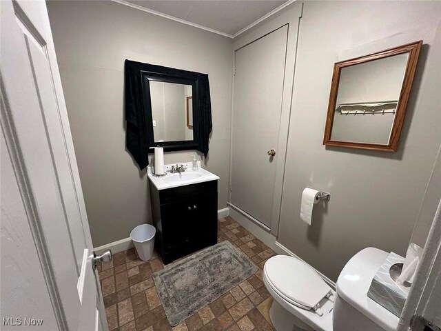 7431 Middlebranch Ave NE, Canton, OH 44721 - half bathroom with stone finish floor, toilet, vanity, crown molding, and baseboards