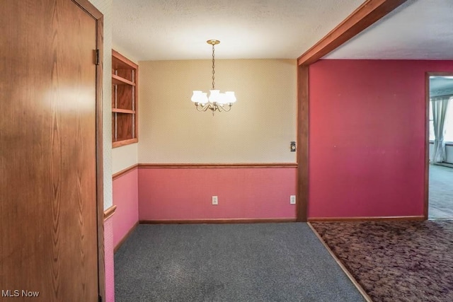 2104 Tanner Ave SW, Canton, OH 44706 - carpeted spare room featuring baseboards, a textured ceiling, and a notable chandelier