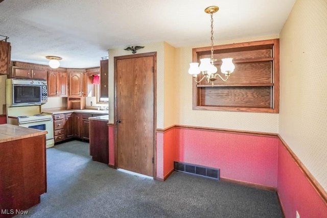 2104 Tanner Ave SW, Canton, OH 44706 - kitchen featuring visible vents, a chandelier, wallpapered walls, dark carpet, and white range with electric stovetop