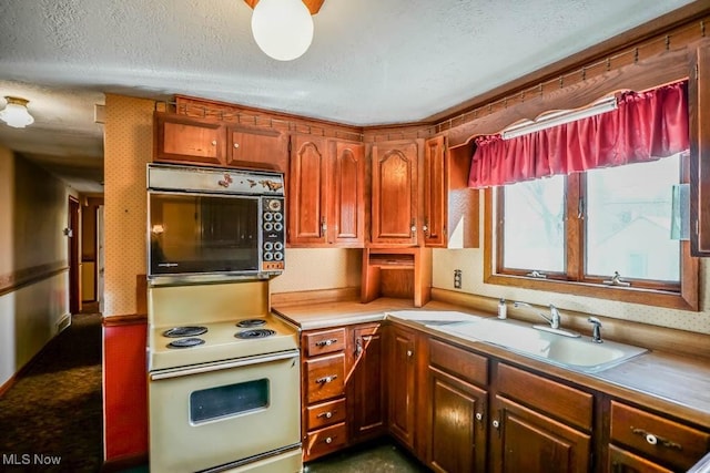 2104 Tanner Ave SW, Canton, OH 44706 - kitchen featuring white electric stove, light countertops, a sink, wall oven, and a textured ceiling