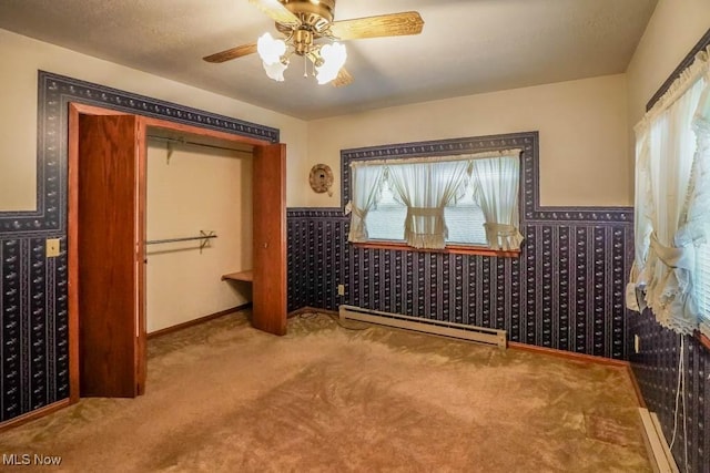 2104 Tanner Ave SW, Canton, OH 44706 - carpeted bedroom featuring a baseboard heating unit, wainscoting, and ceiling fan