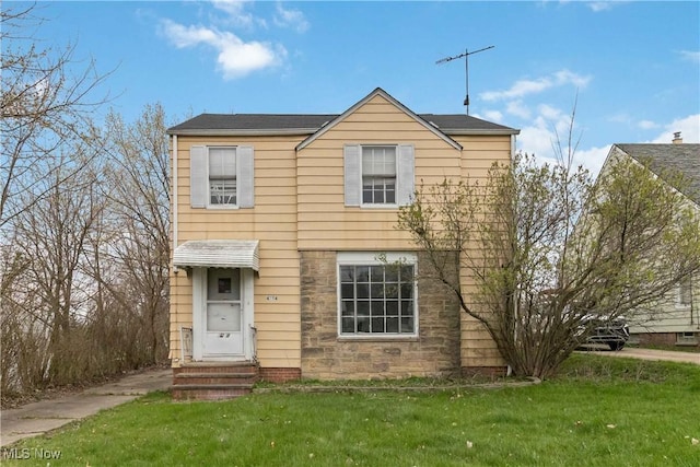 view of front facade featuring a front lawn, stone siding, and entry steps