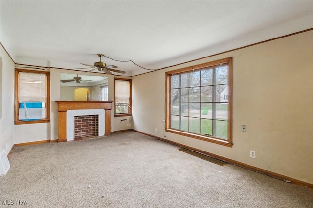 unfurnished living room with a wealth of natural light, visible vents, and baseboards