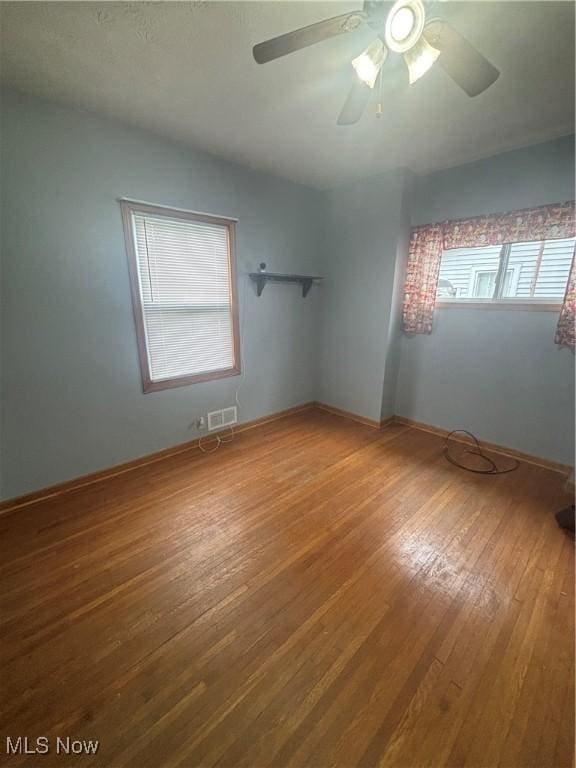 405 Oak Knoll Ave SE, Warren, OH 44483 - empty room with baseboards, hardwood / wood-style flooring, visible vents, and a ceiling fan