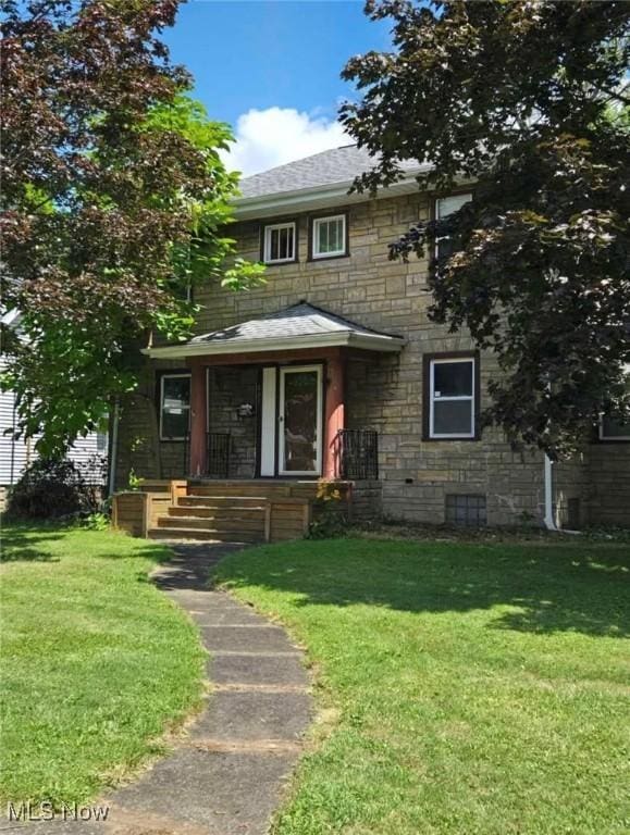 405 Oak Knoll Ave SE, Warren, OH 44483 - view of front facade with stone siding, a shingled roof, and a front lawn