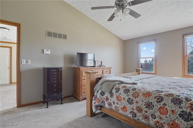 bedroom with vaulted ceiling, a textured ceiling, ceiling fan, light carpet, and visible vents