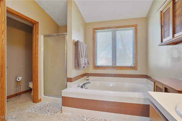 bathroom with a shower stall, tile patterned flooring, toilet, vanity, and a garden tub